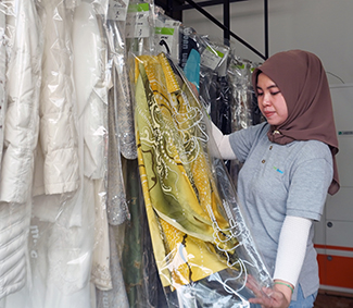 Hijabi woman with a bag of clothes in hand